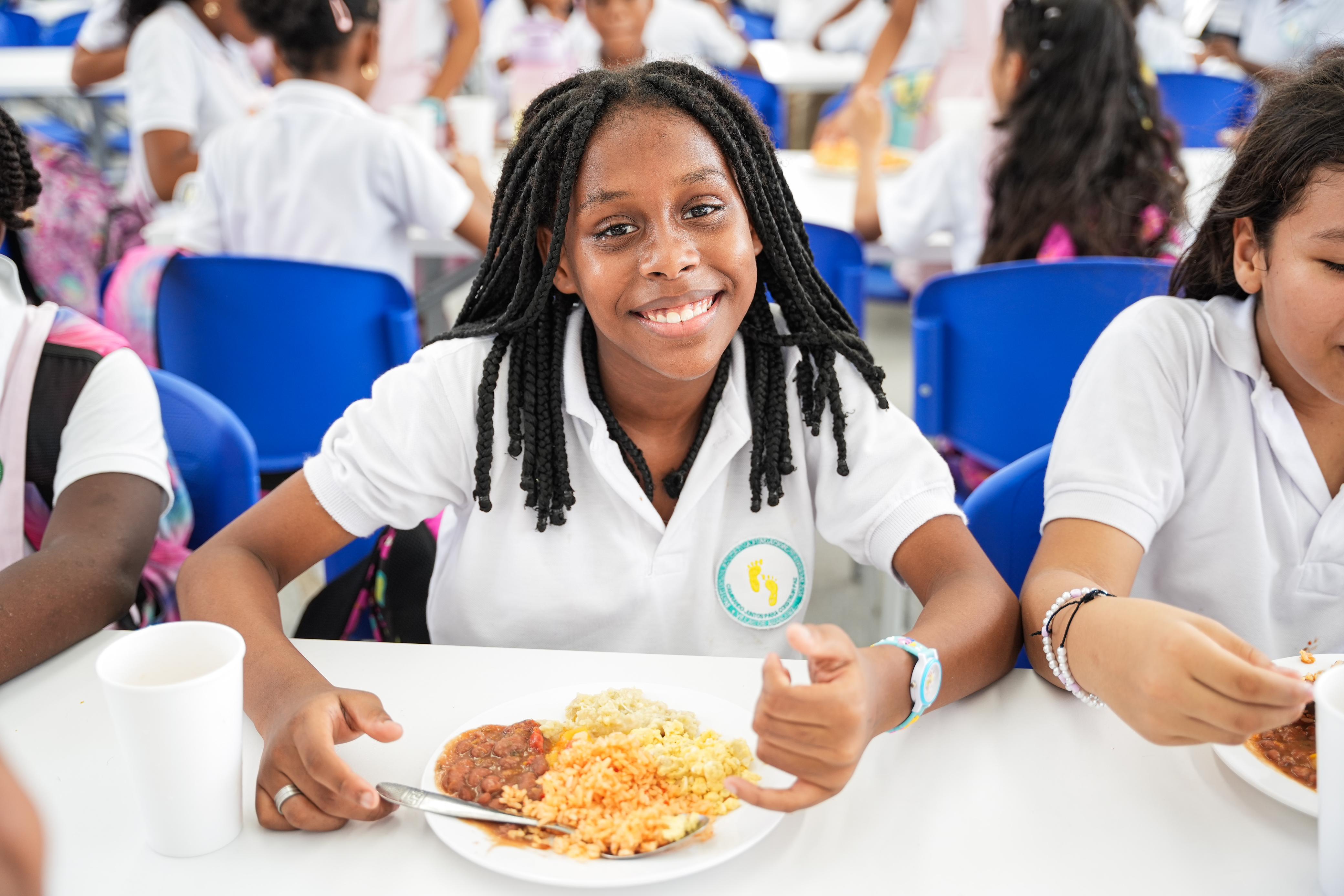 Estudiante beneficiaria del PAE con un plato de comida